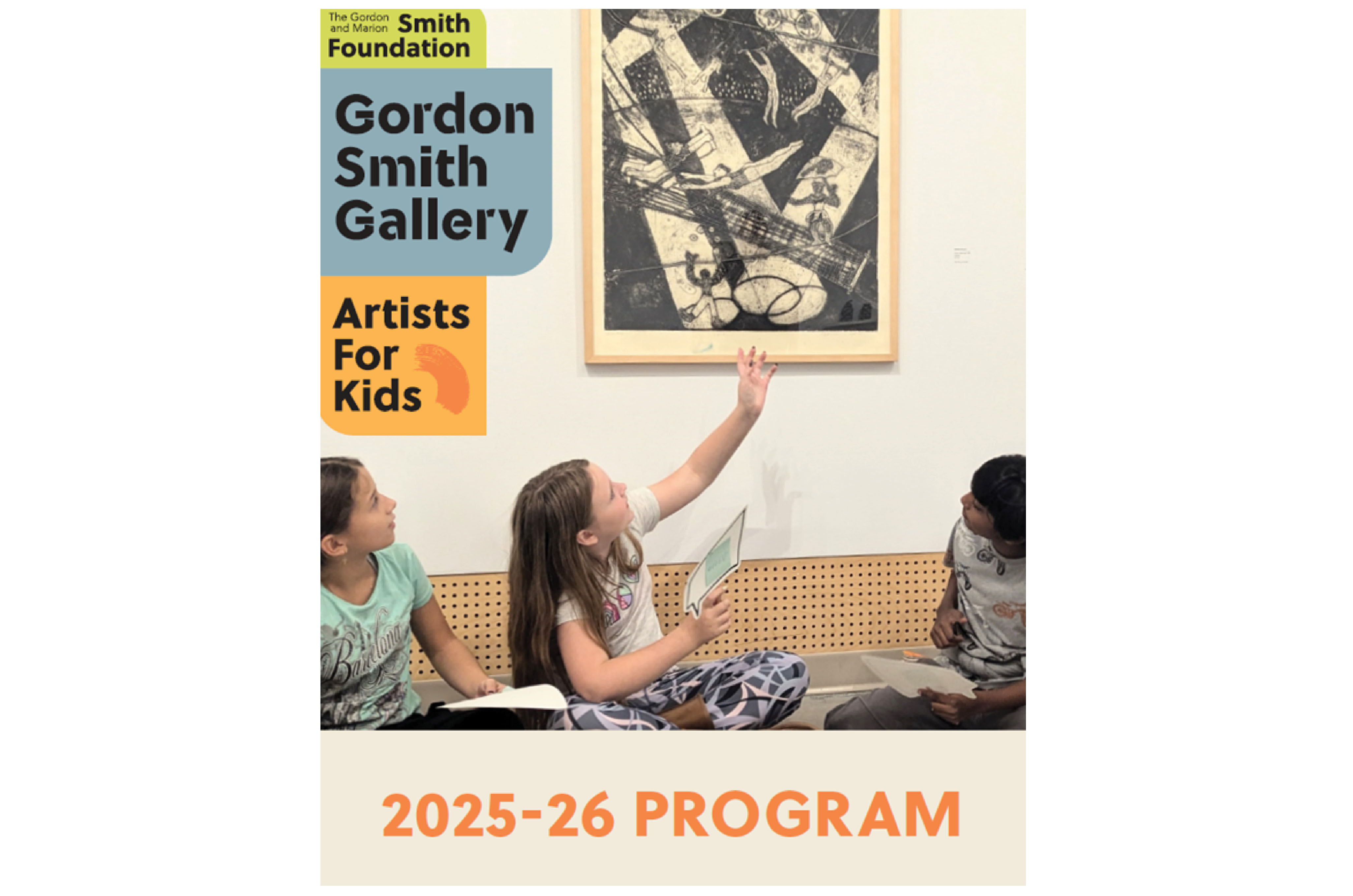 three students sitting under an art print, centre student pointing up to it