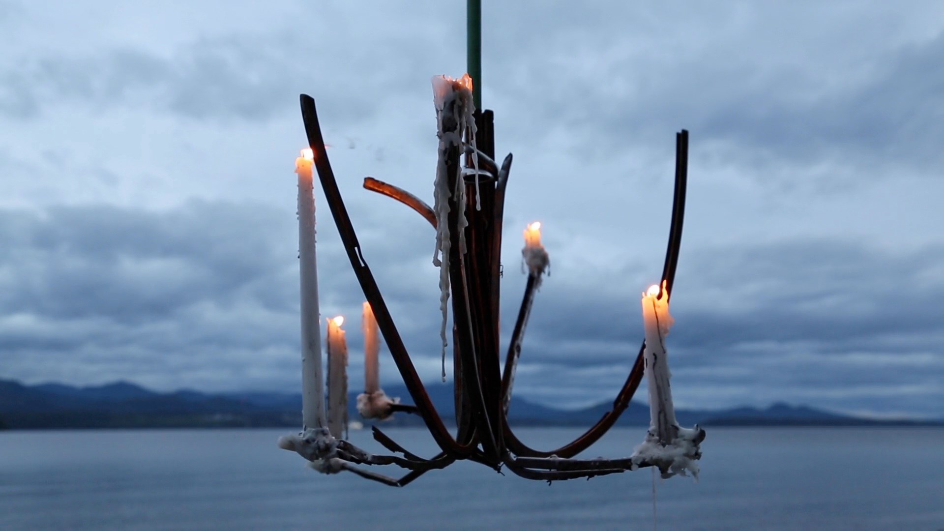a candelabra hanging against cloudy summer night sky over ocean
