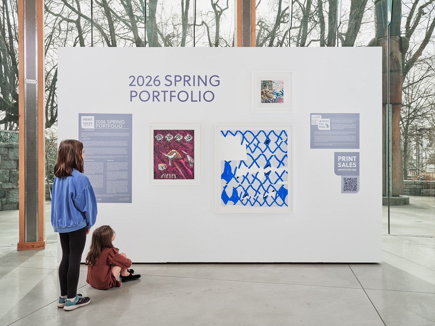 Two students looking at gallery display of the 2026 spring portfolio prints