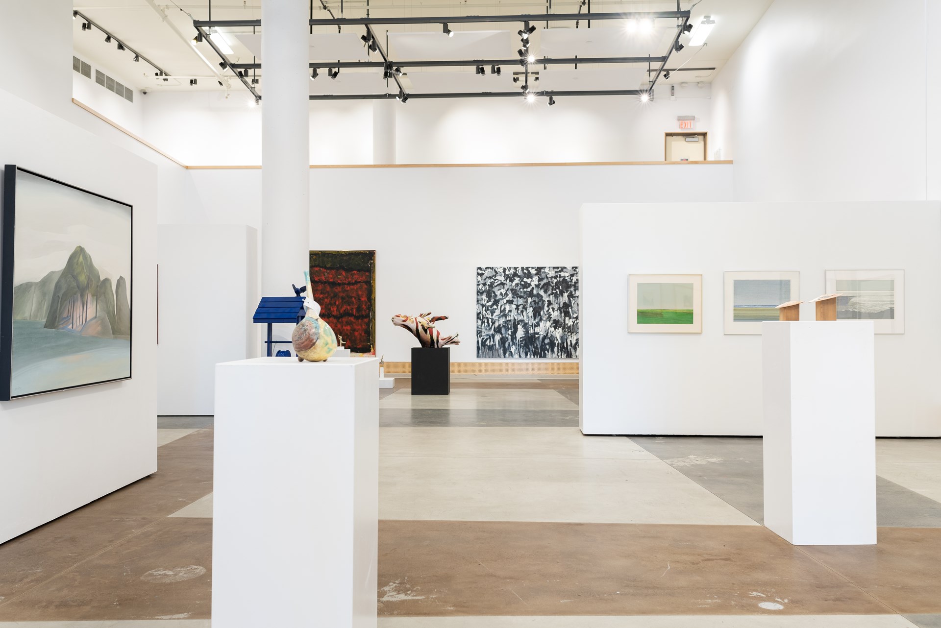 Interior view of GS Gallery with hung art in the background and some sculptures on plinths