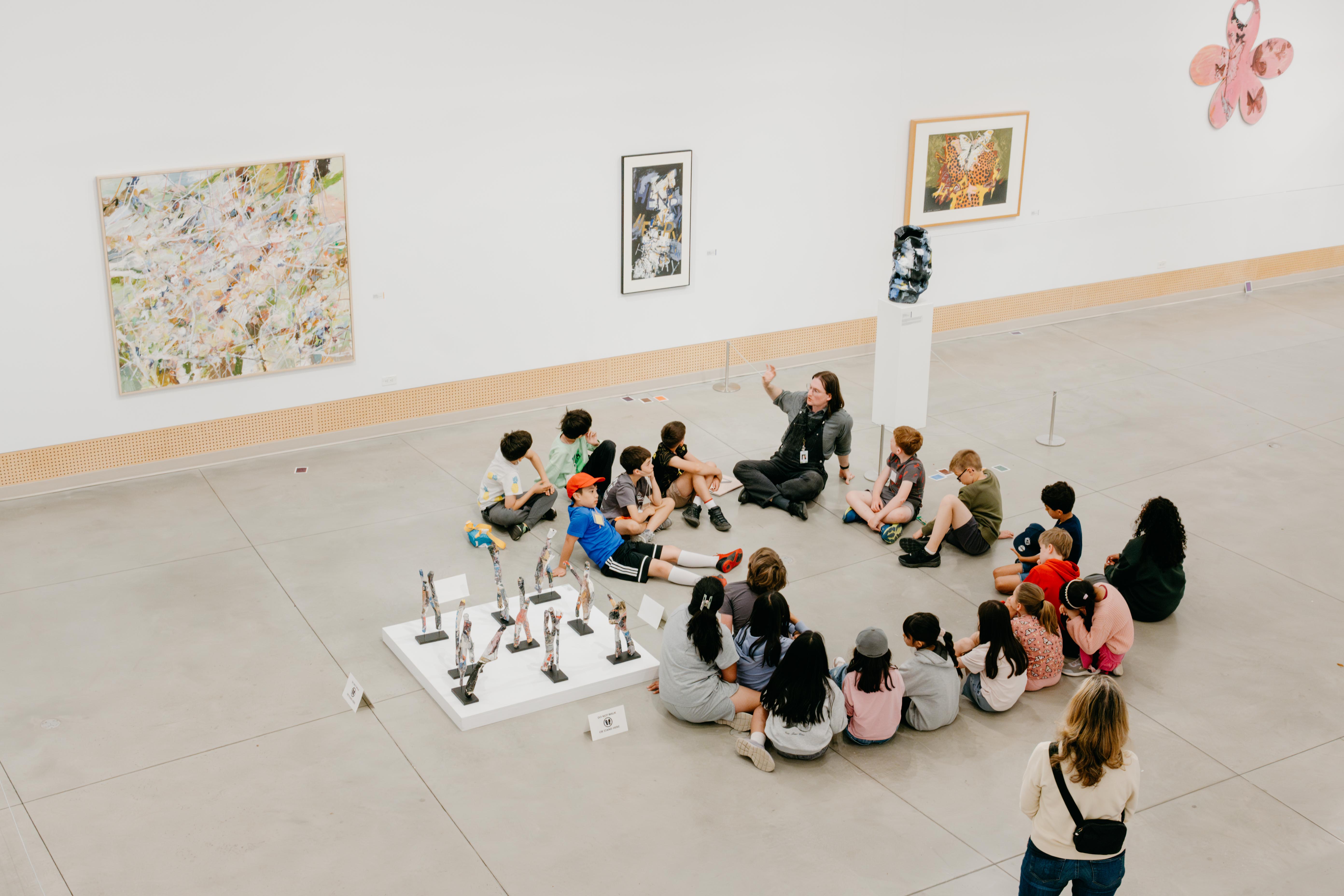 Students sitting in a circle in the gallery for Artists for Kids Gallery Program